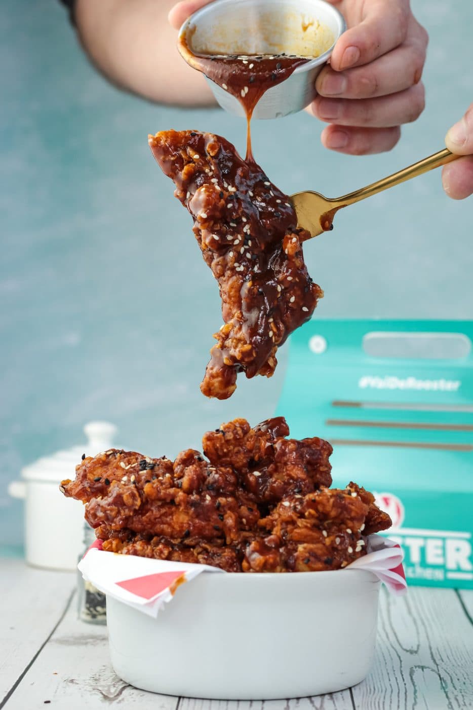 Frango frito crocante com molho sendo finalizado